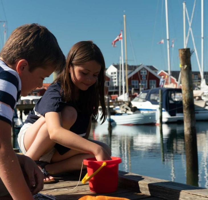 Two children catching crabs on the crabbing jetty in Juelsminde Harbour