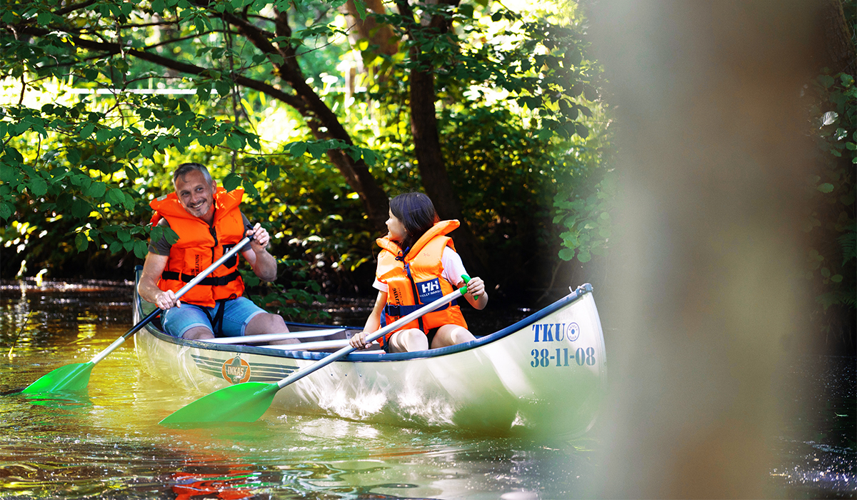 Vater und Tochter fahren im Kanu auf dem Gudenå im Küstenland