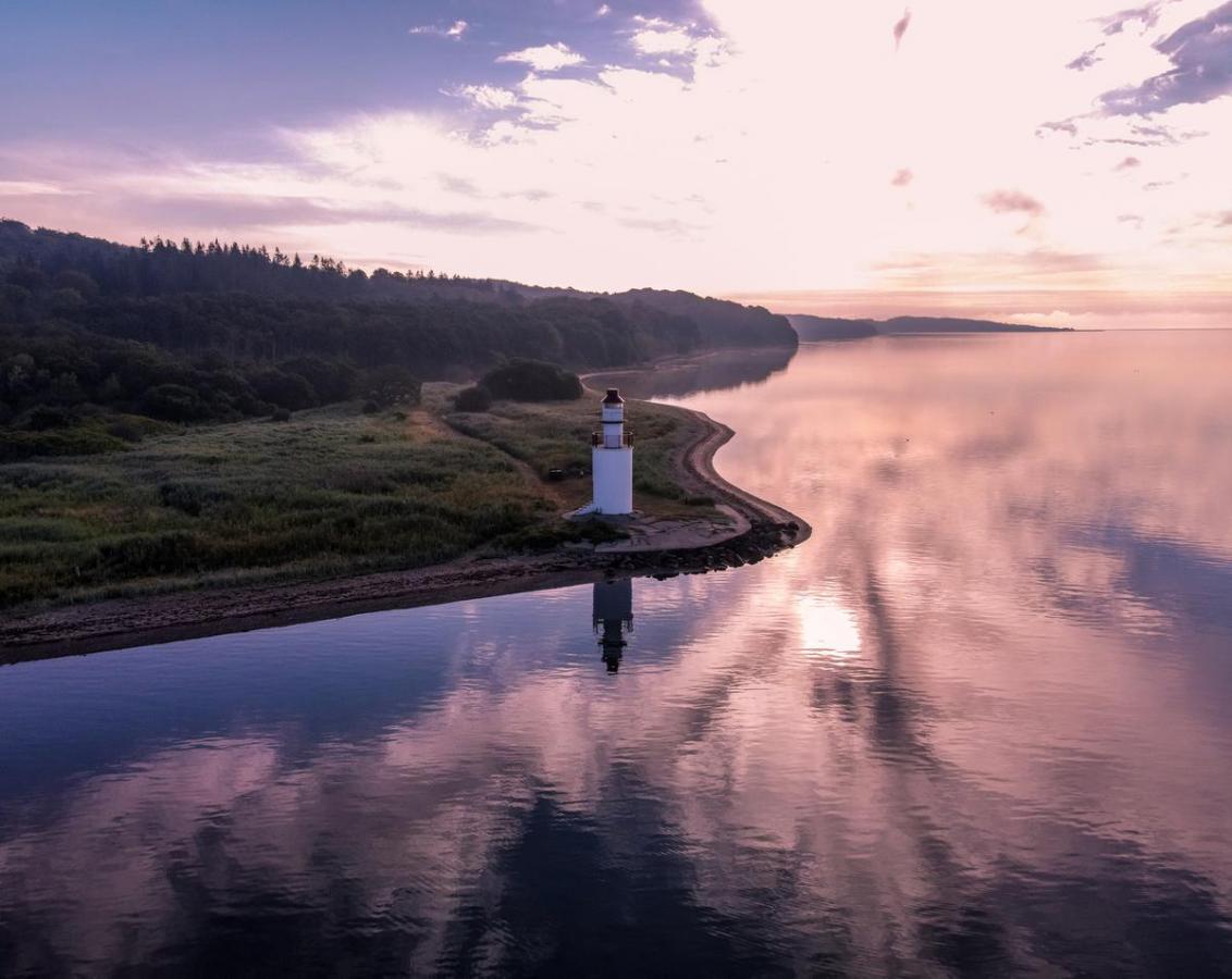 View of the coastal line and lighthouse in the area of Hotel Vejlefjord in the coastal land