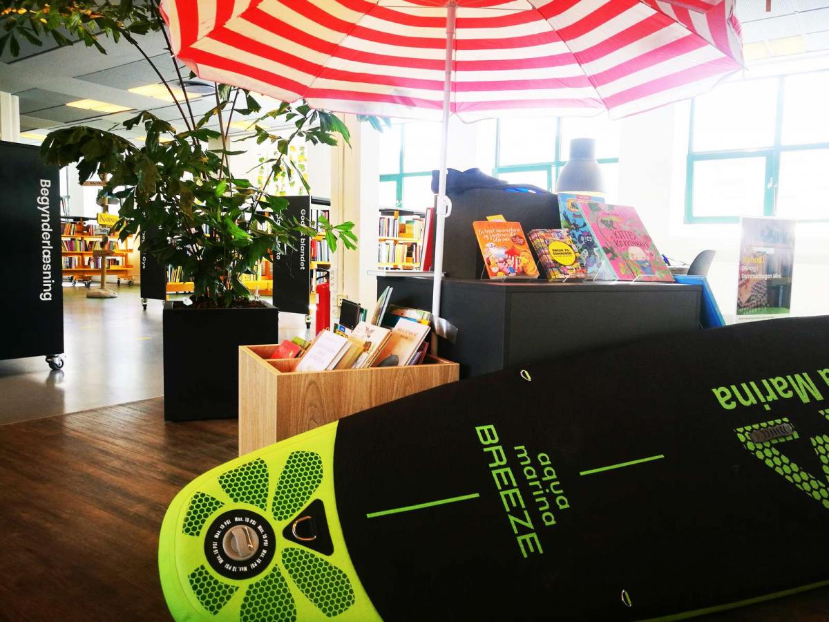 Sommerexponat mit SUB Board, Sonnenschirm und Sommerlesung in den städtischen Büchereien von Horsens