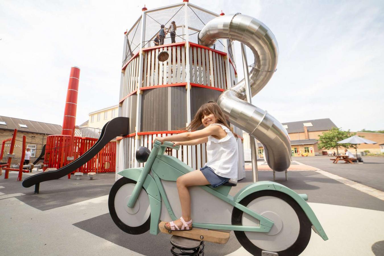 Girl sitting on a rocking motorcycle on the Industrial Museum’s playground