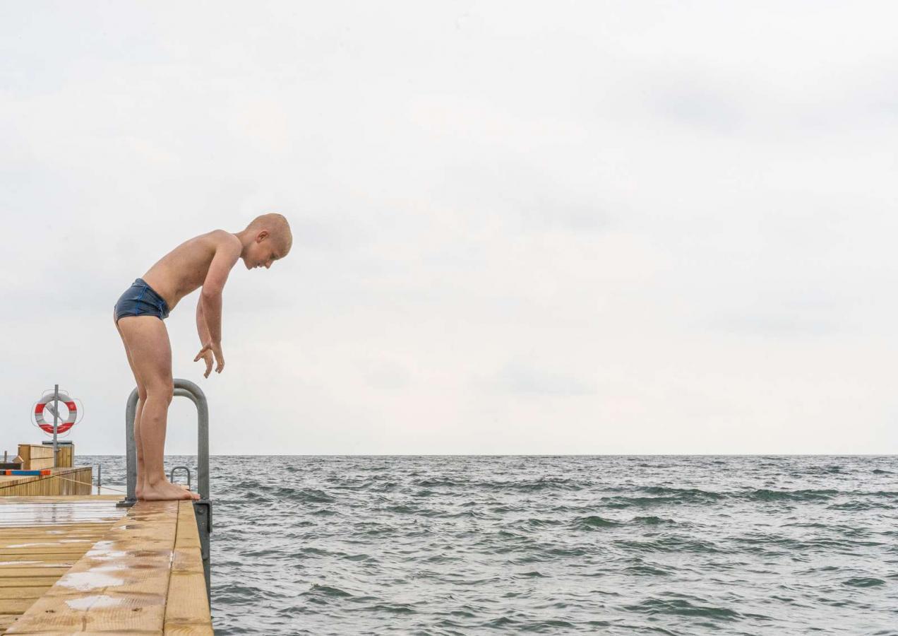 Boy standing on the jetty at Storstranden