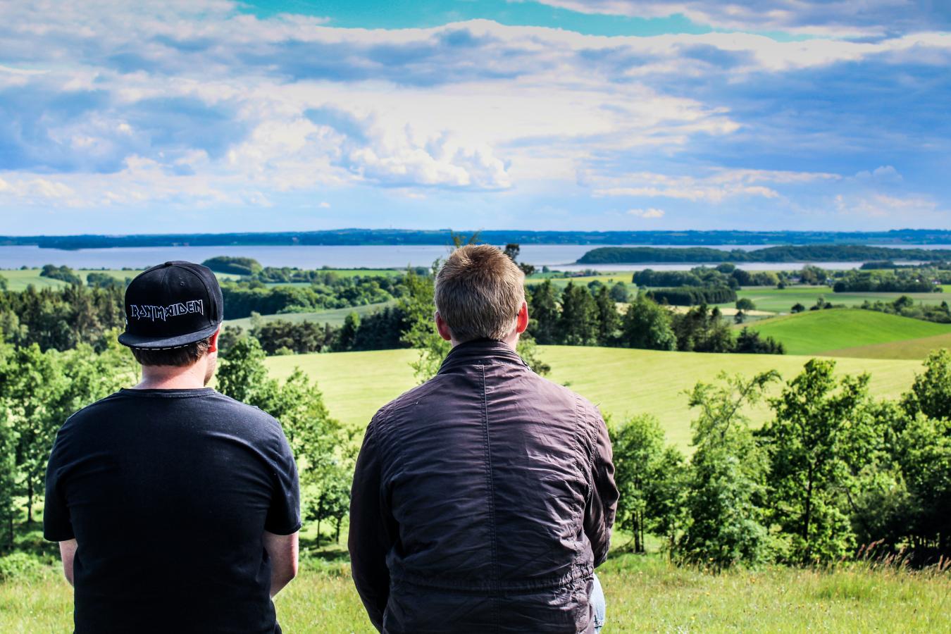 Two boys sit and enjoy the view from Trustrup Udsigtshøje