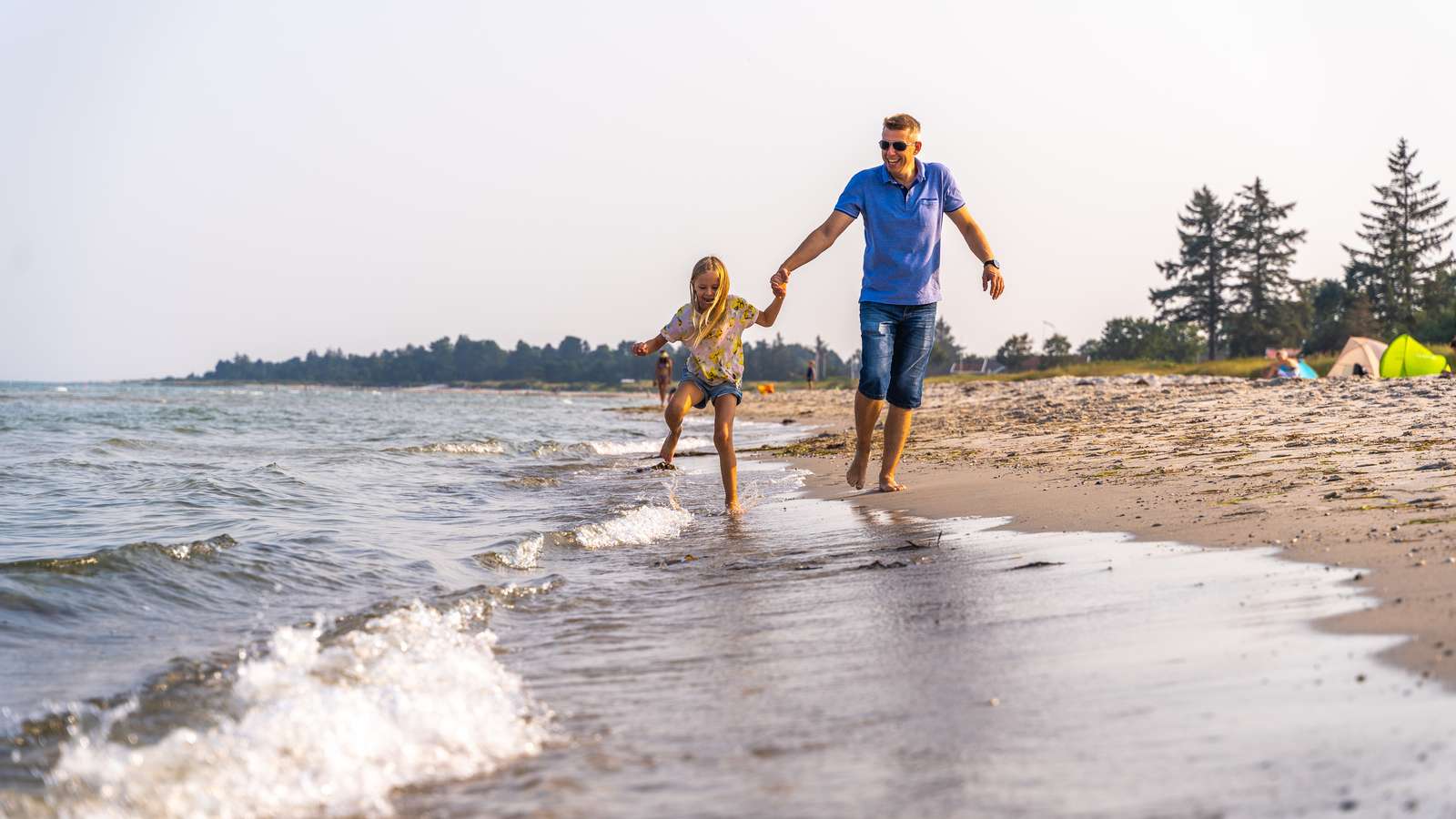 Vater und Tochter an der Wasserkante am Saksild Strand
