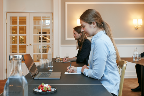 Two attendee sits at a table at a meeting in Hotel Jørgensen in Horsens