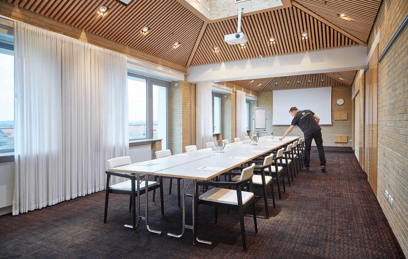 Emplory prepping the meeting room at  Hotel Opus i Horsens
