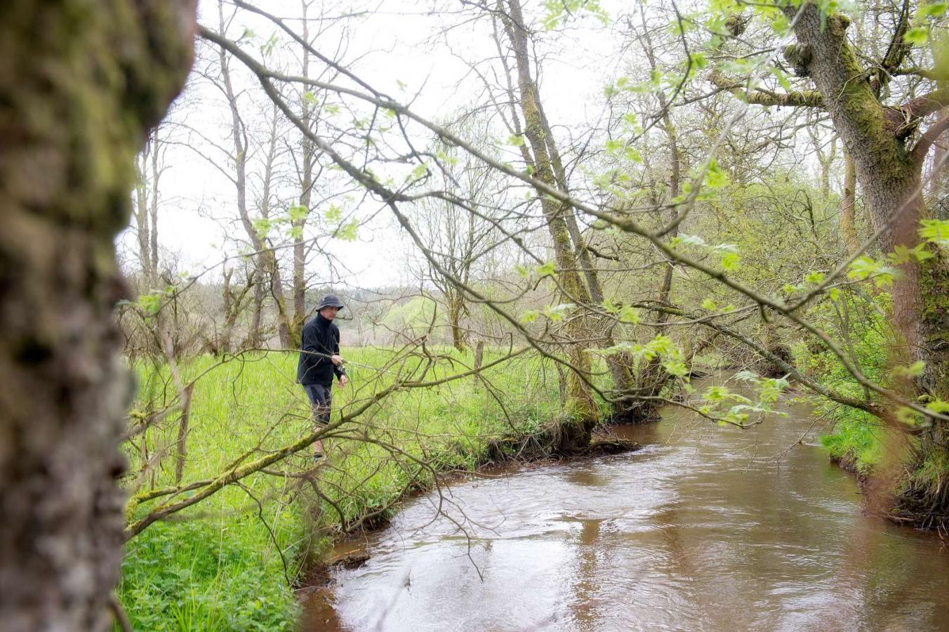 Man fishing from the banks of the river Gudenåen