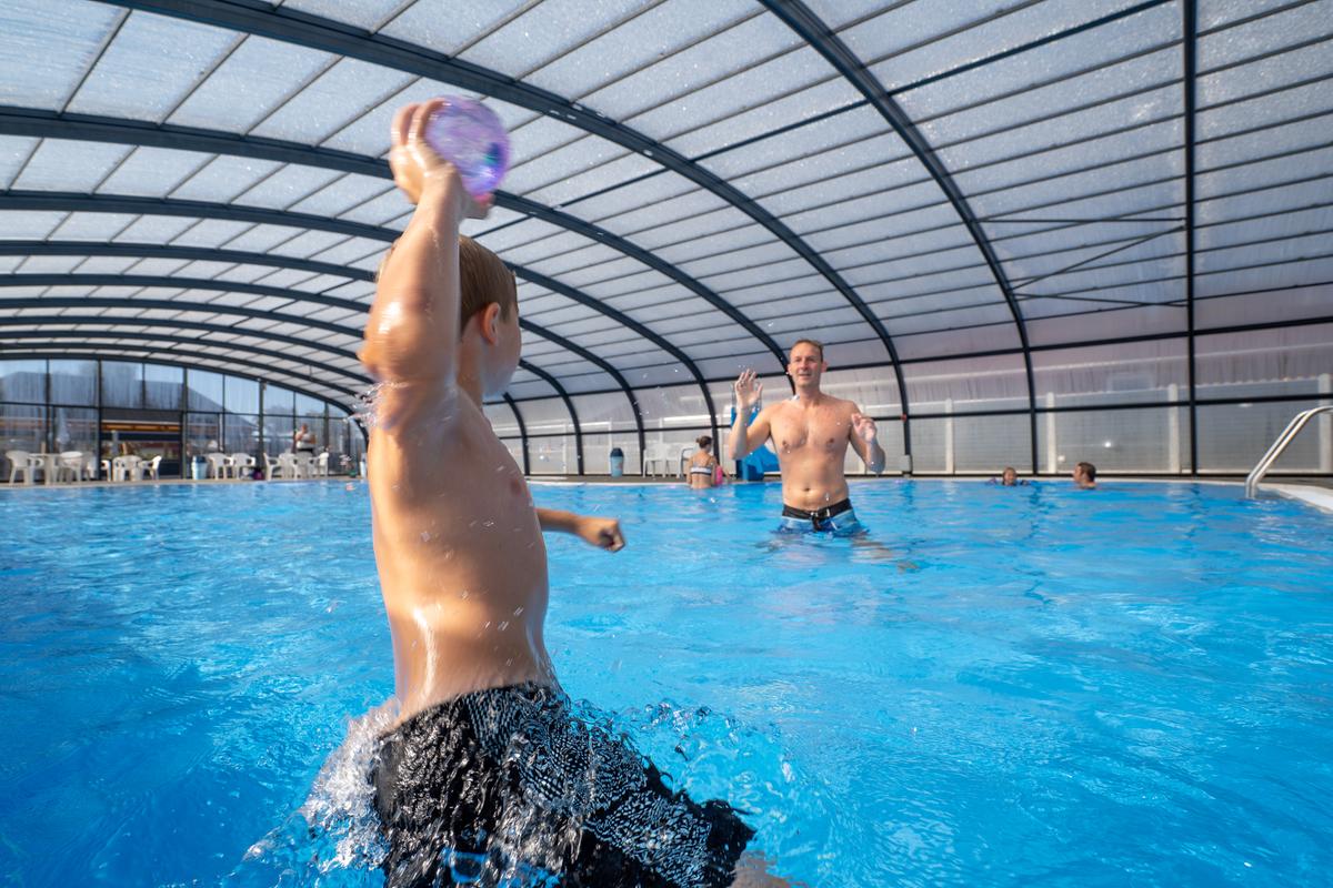 A boy and a father playing ball in a pool at Horsens City Camping near Husodde in Destination Coastal Land