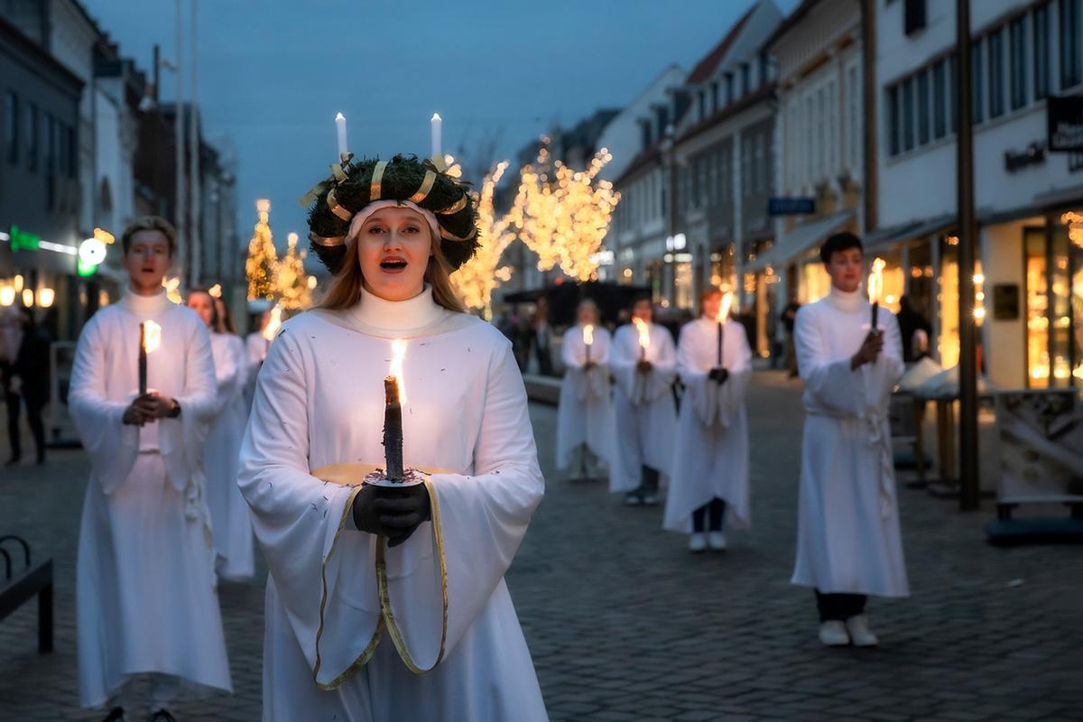 Kvinder i hvide kjoler med lys i hånden til juleaktiviteter og shopping i Destination Kystlandet