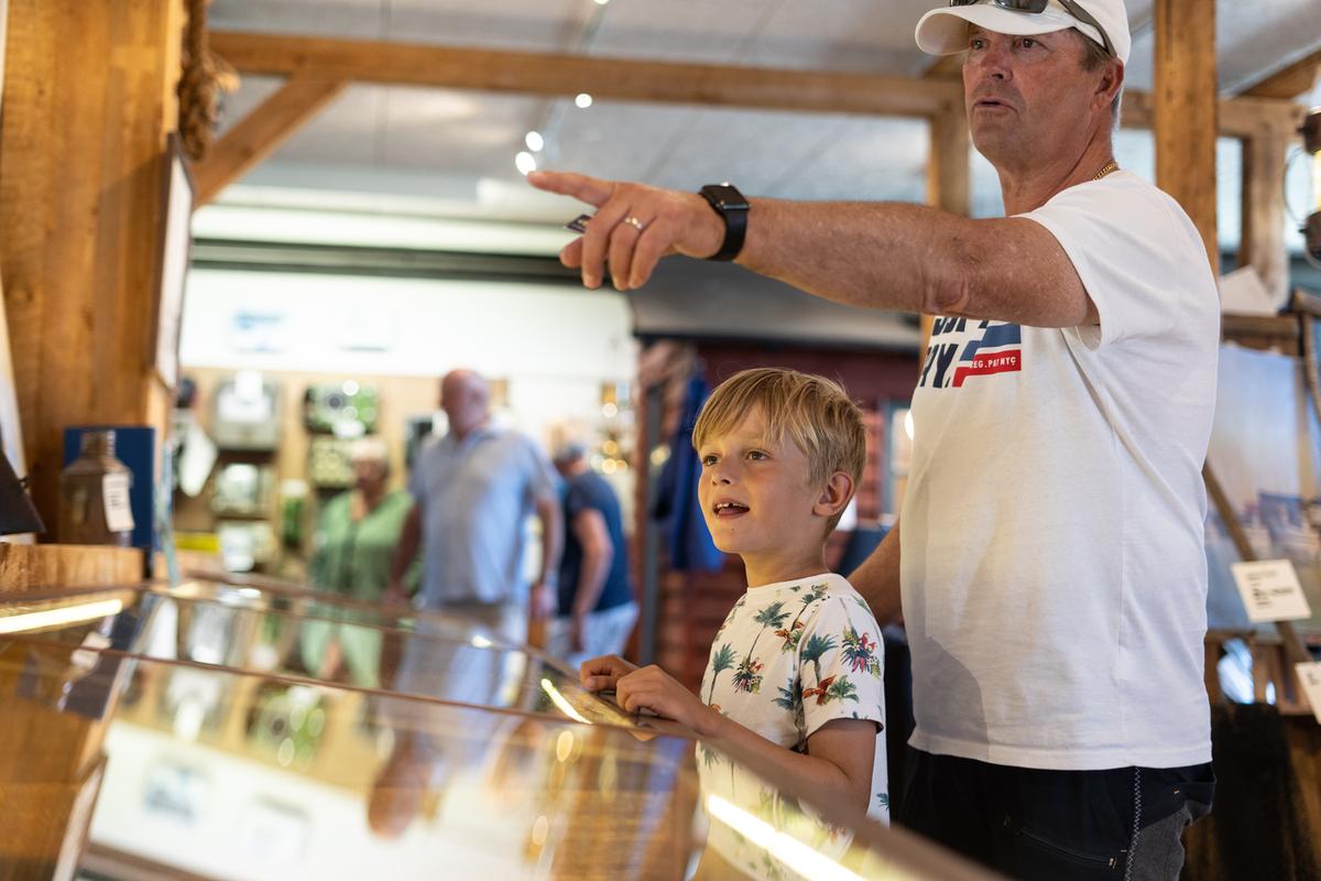 Junge und sein Vater schauen sich die Schiffsausstellung im Hafenmuseum in Juelsminde an