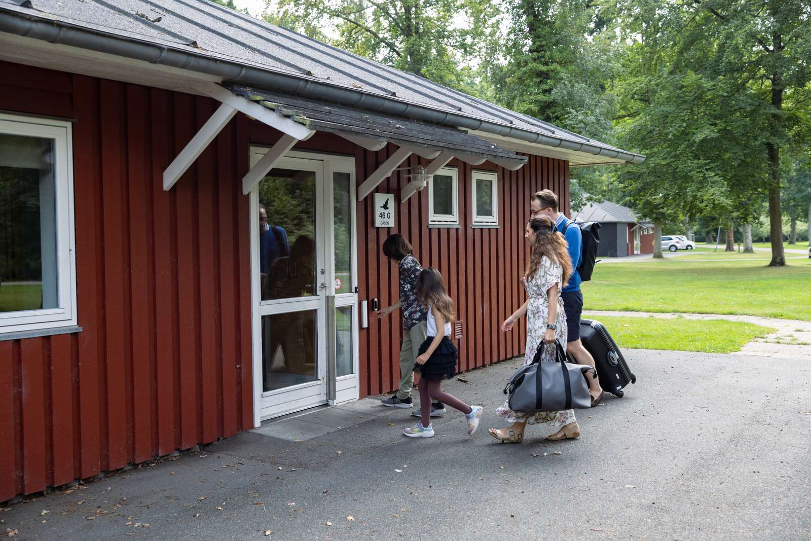 Familie på vej ind i hytte ved Hou Søsportcenter