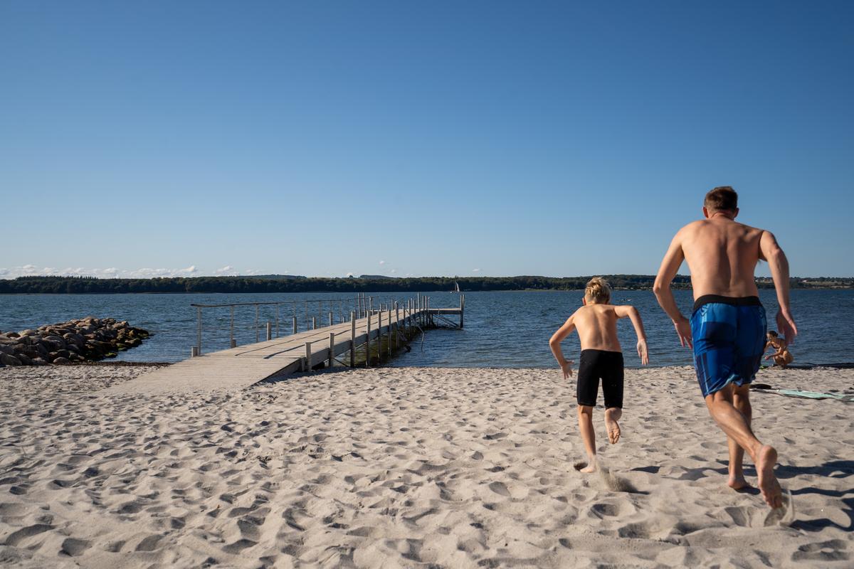 Far og søn løber mod vandet på Husodde Strand