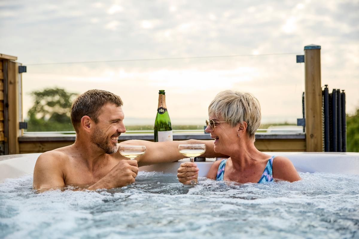 Et par skåler i champagne i en udespa hos Hygge Strand Camping