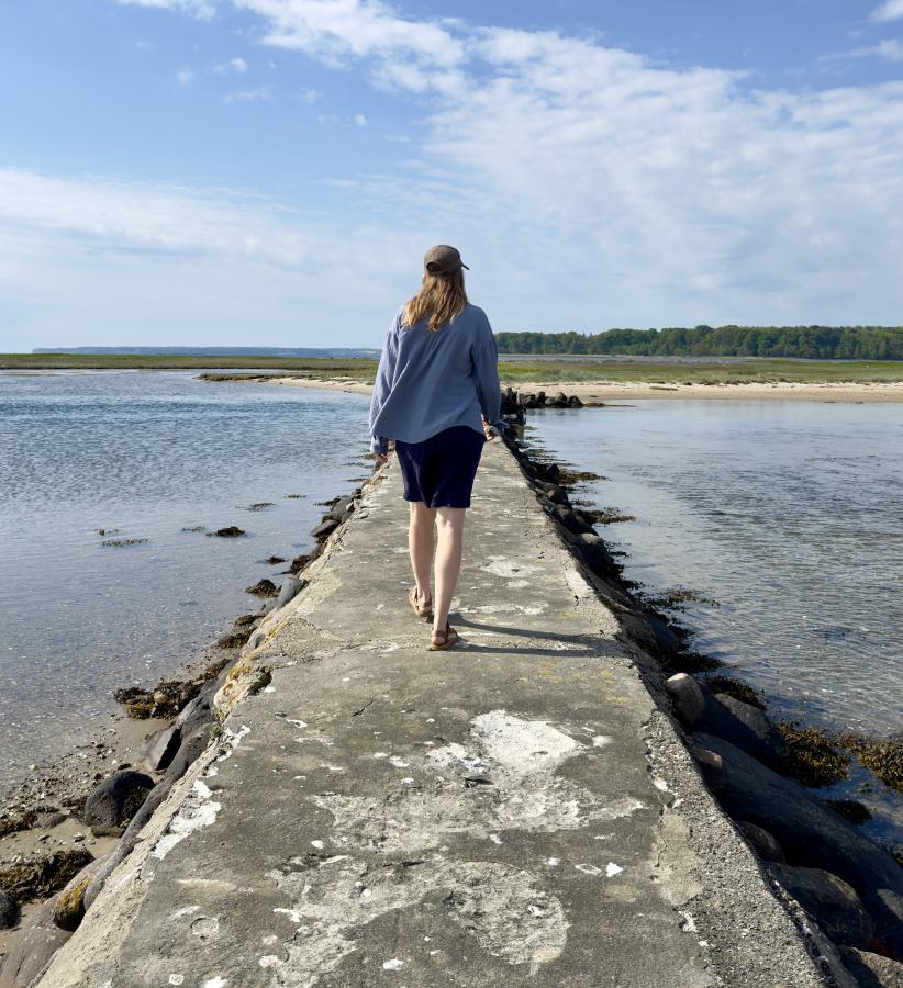 Kvinde går på broen på lagunen på Hjarnø