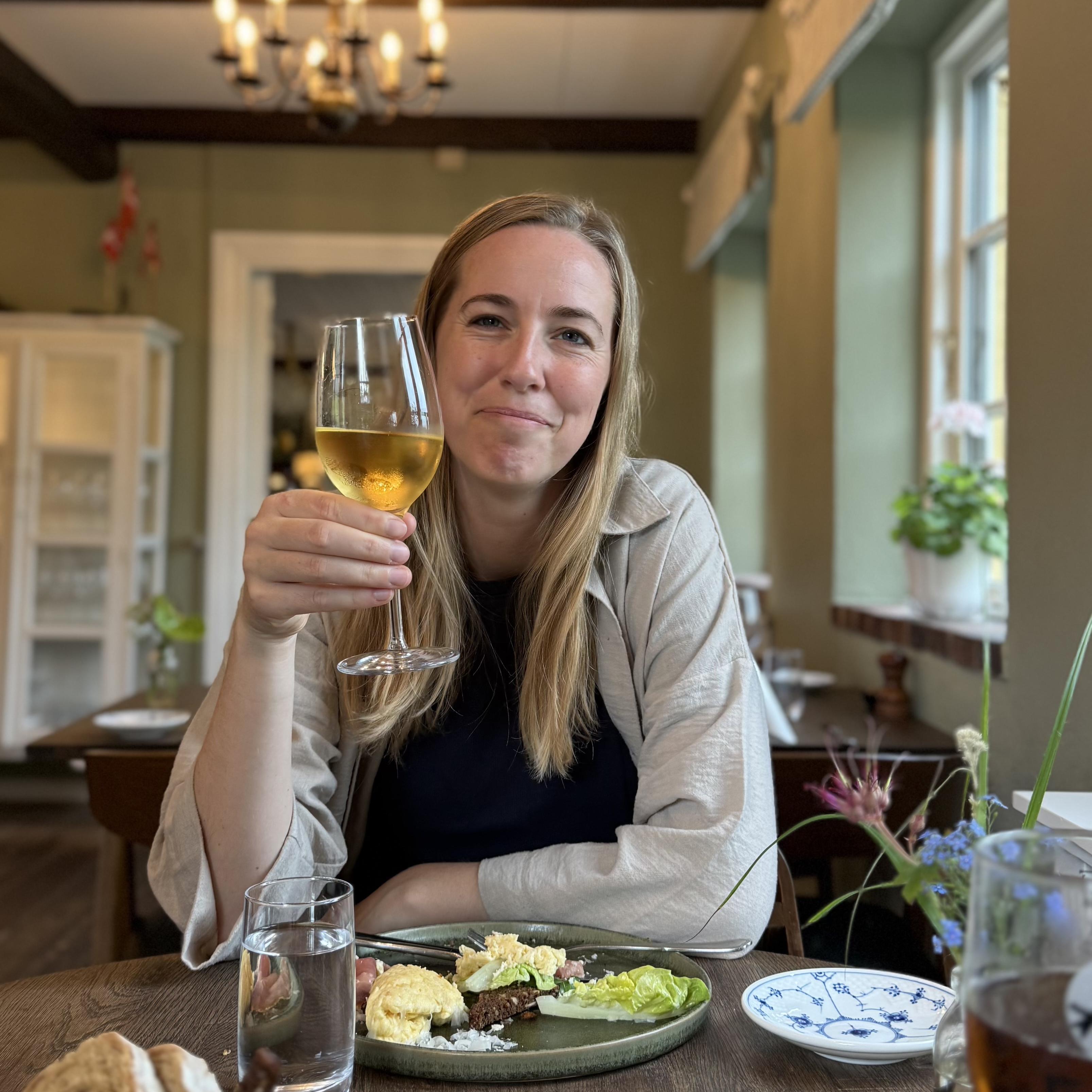 Carina Hindkjær fra Drømmesteder spiser frokost og skåler i hvidvin hos Sandvad Kro