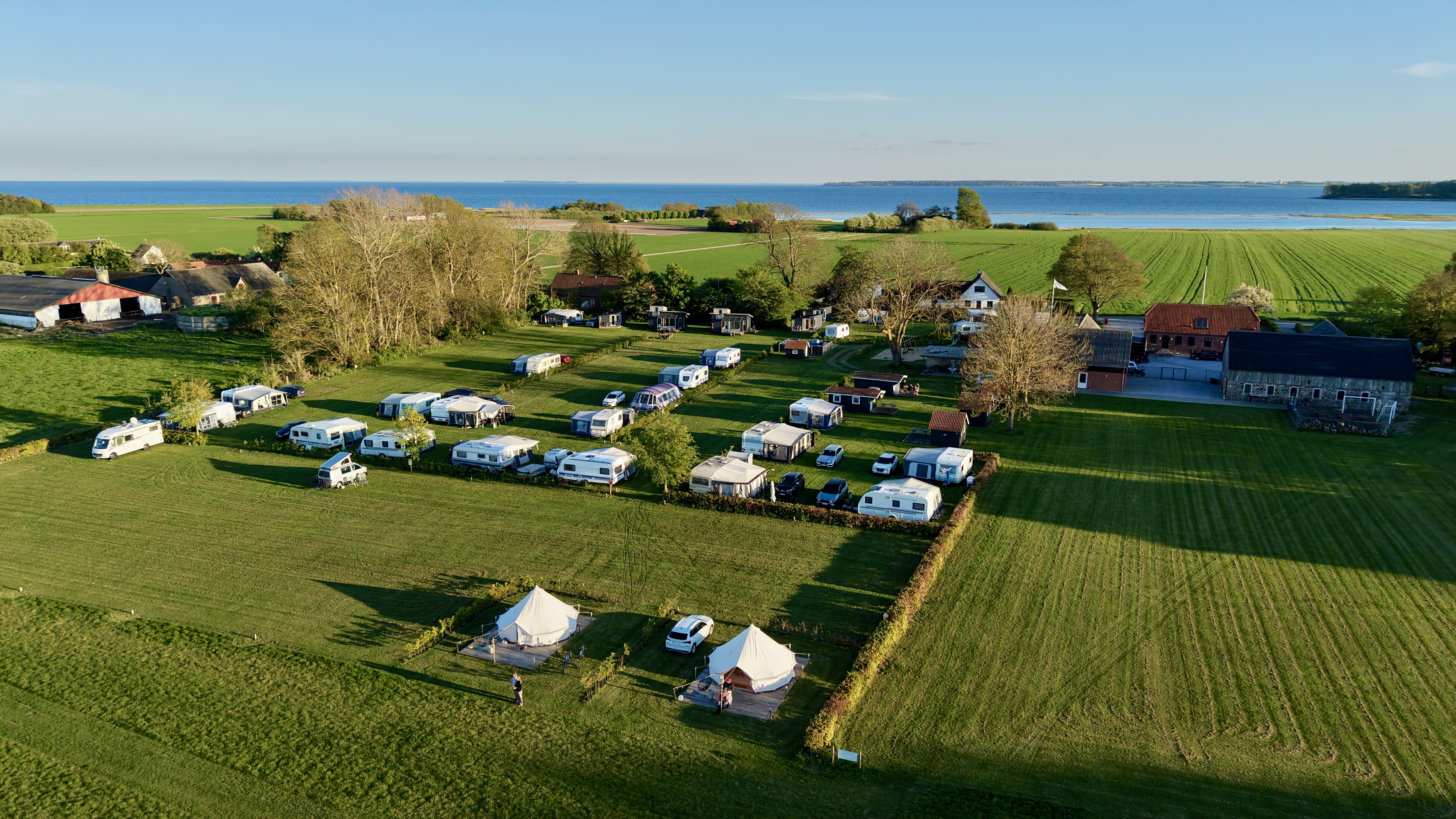 Luftfoto af Hjarnø Camping med Horsens Fjord i baggrunden