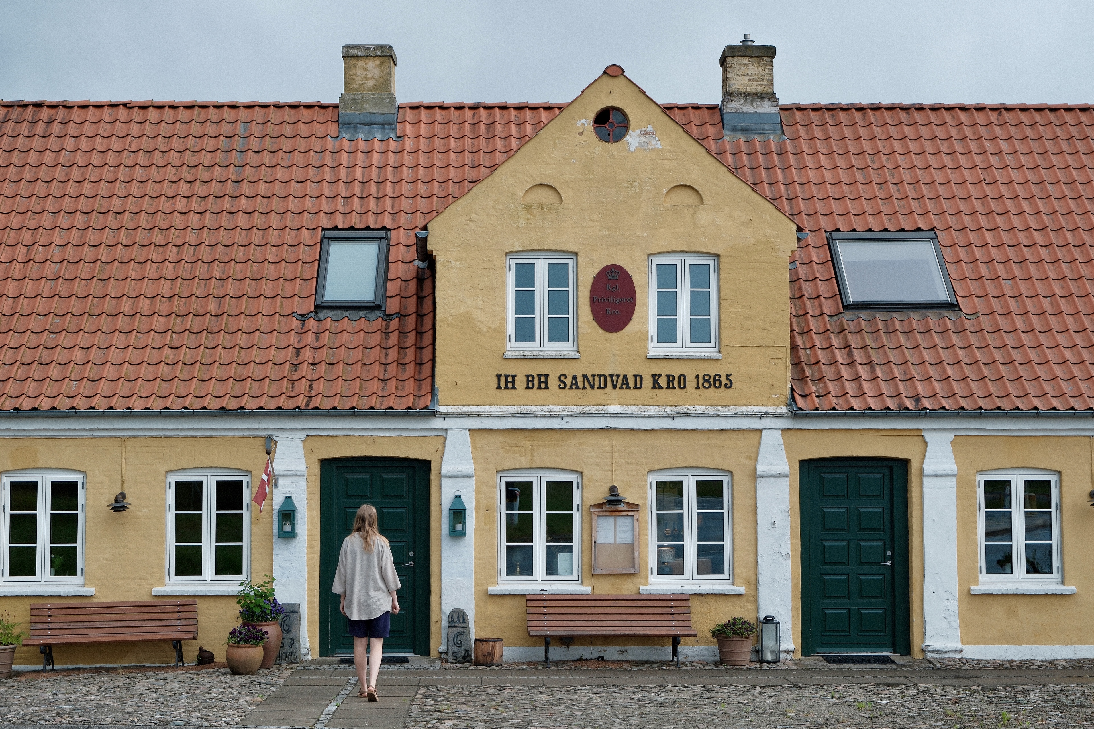 Kvinde går mod indgangen til Sandvad Kro