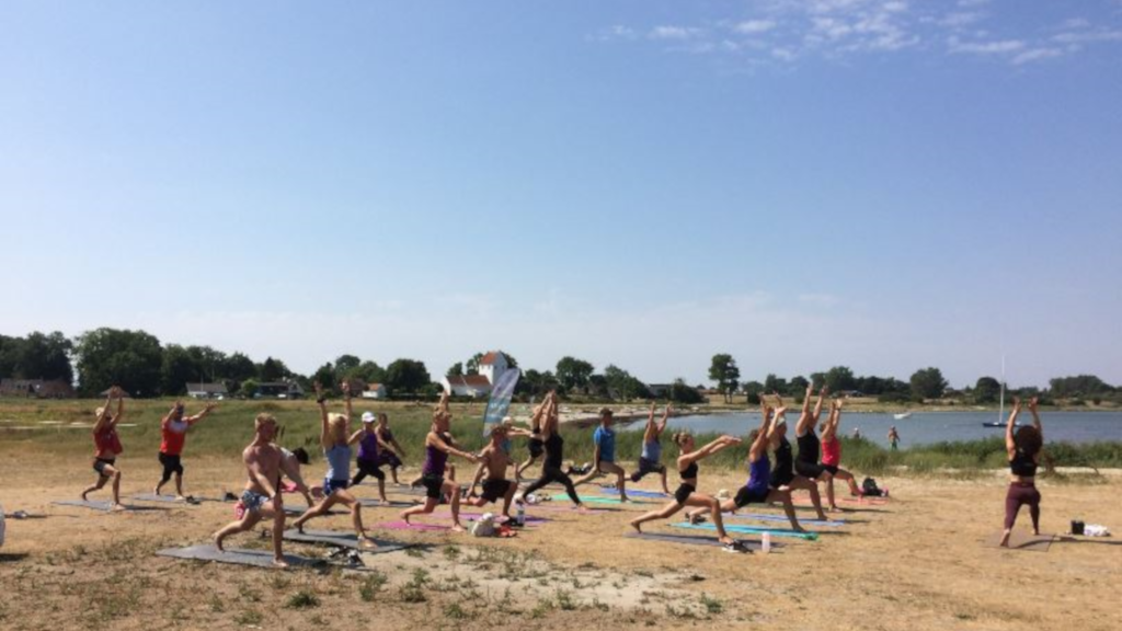 En gruppe dyrker yoga på stranden på Endelave