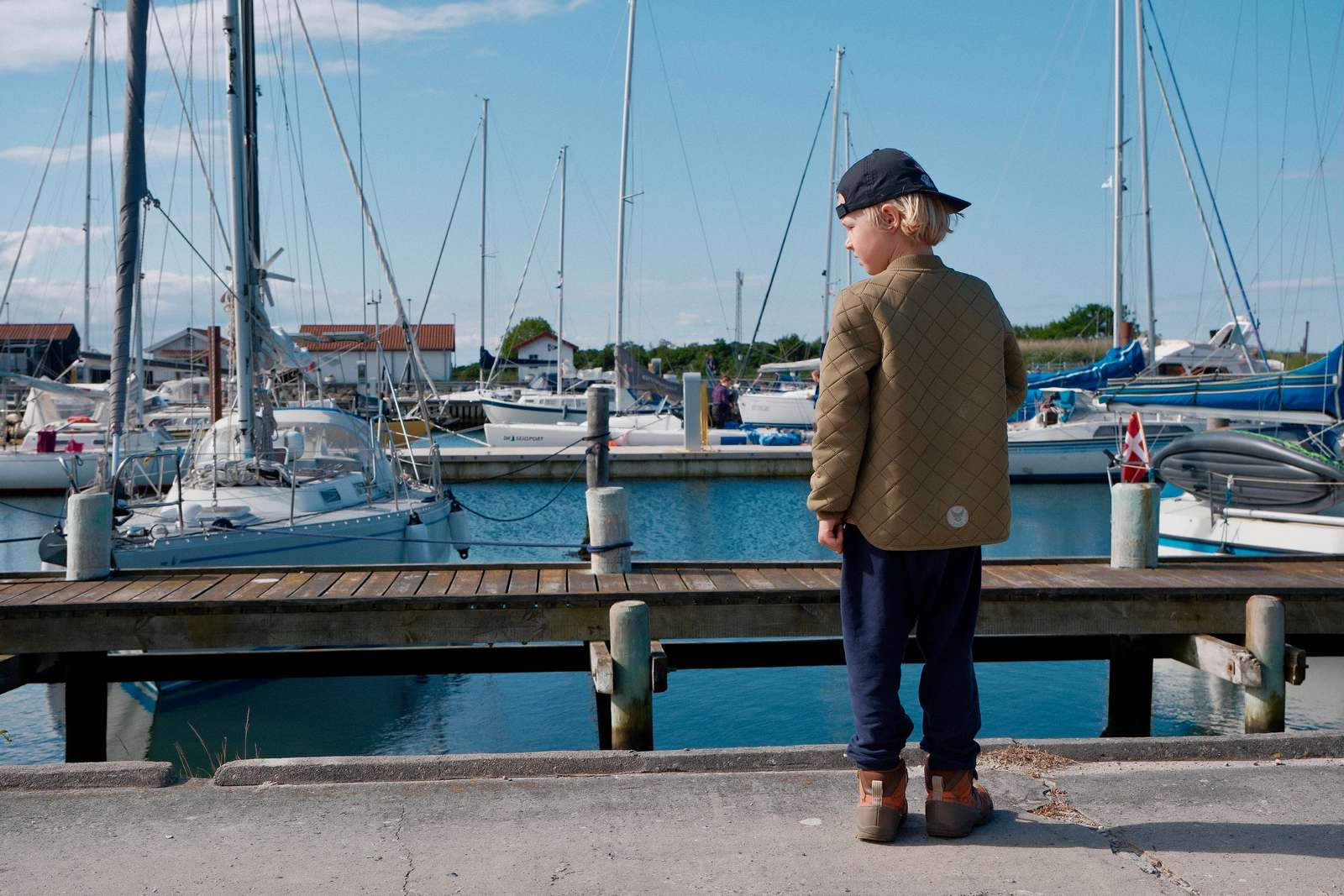 Dreng kigger på både på Tunø Havn