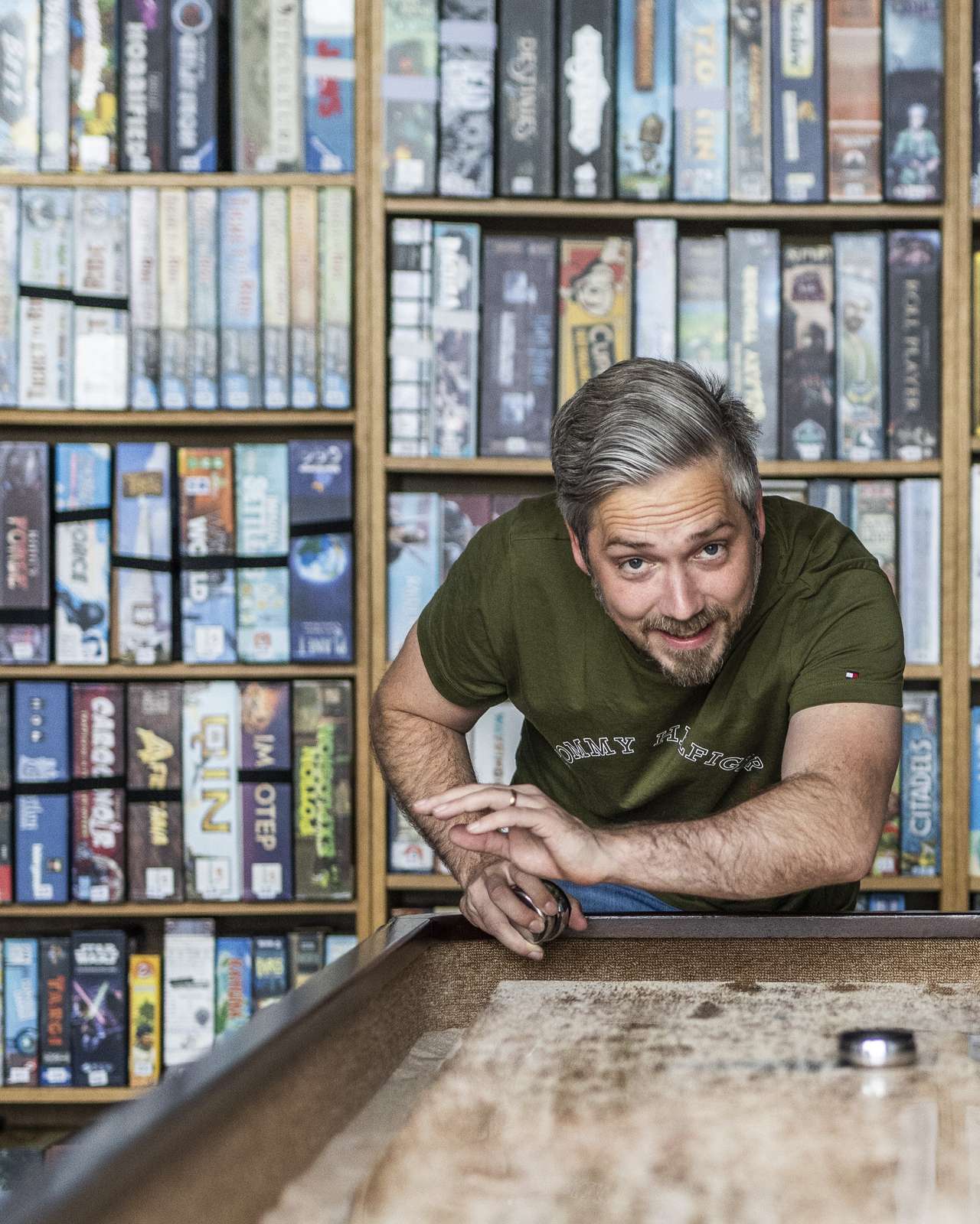 En mand spiller shuffleboard i Brætspilscaféen i Horsens