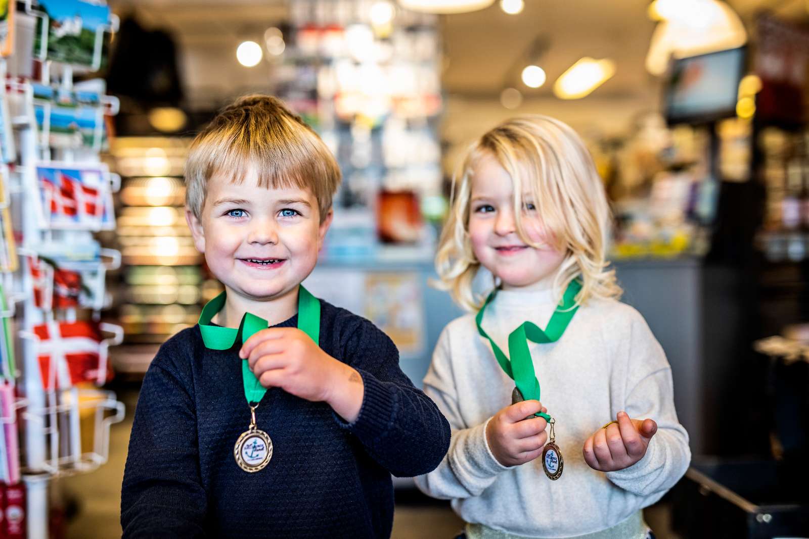 To børn poserer med medaljer fra skattejagten i Juelsminde