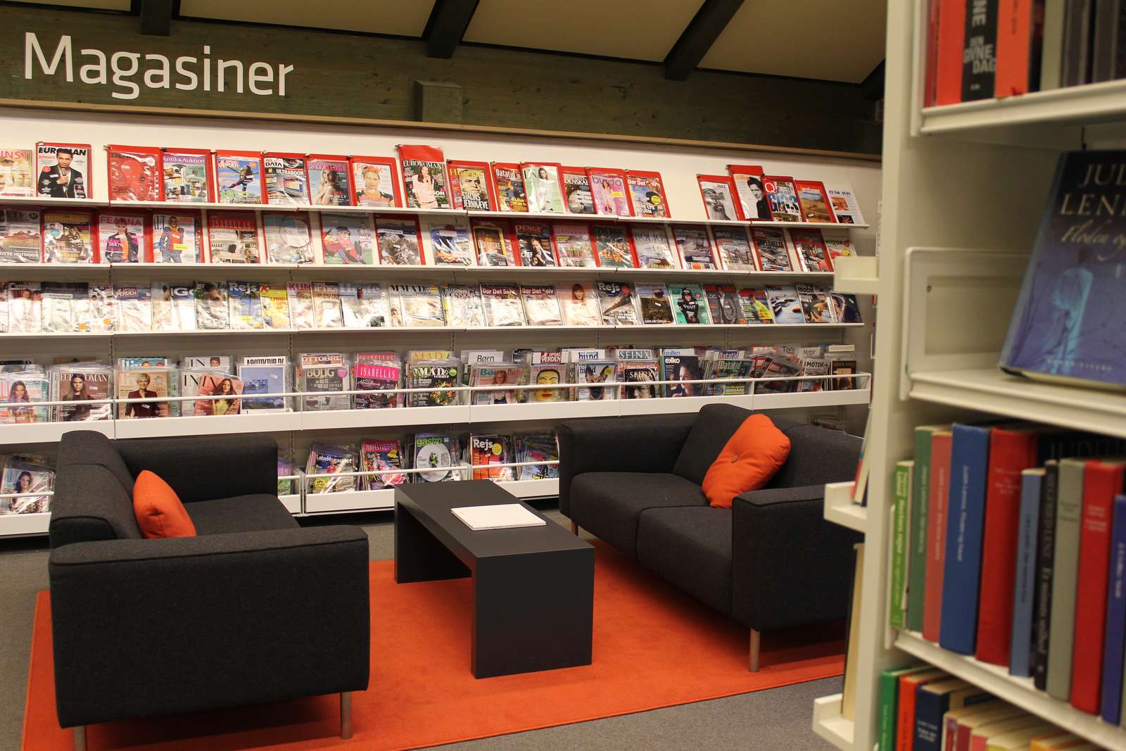 Sofaer i Odder Bibliotek foran en reol med magasiner