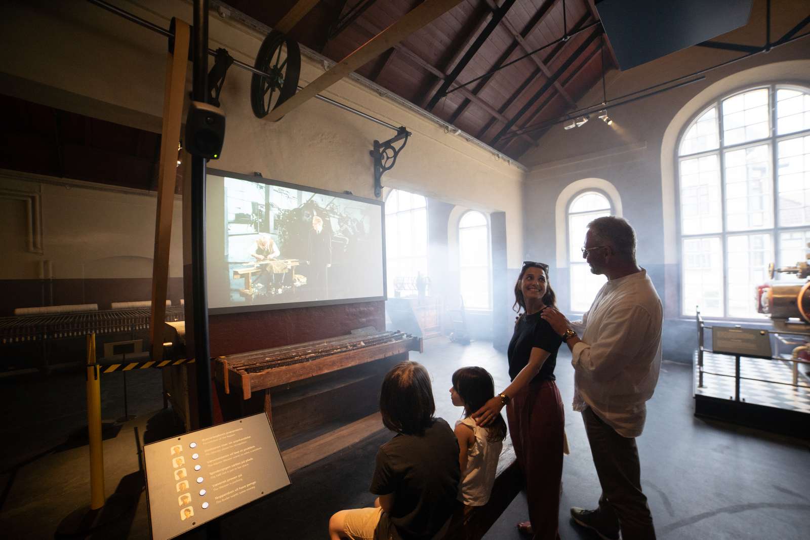 Familie kigger på skærm i tekstilfabrikken på Industrimuseet