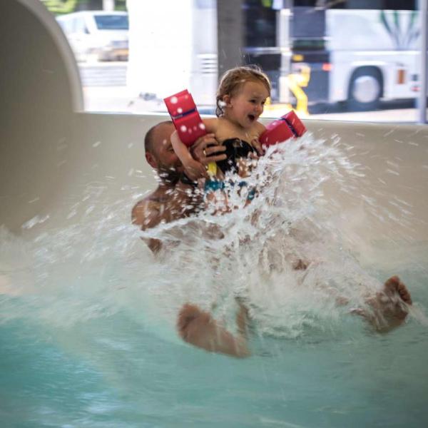 Father and daughter flying out of the water slide at Valhalla, Hou