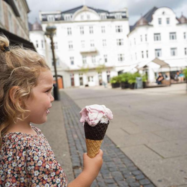 A girl holding an ice cream in front of Centralhotellet in Odder