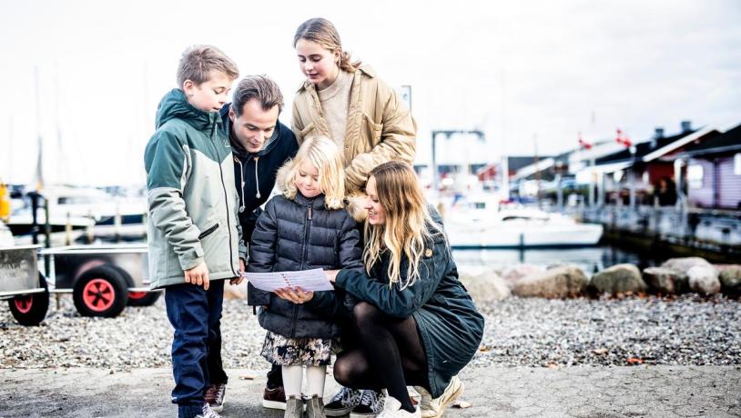 Family looking at a treasuremap on Juelsminde Harbour