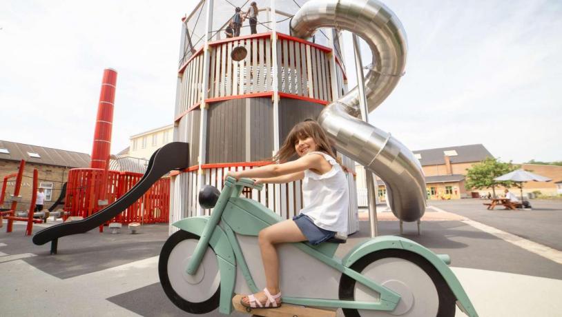 Girl sitting on a rocking motorcycle on the Industrial Museum’s playground