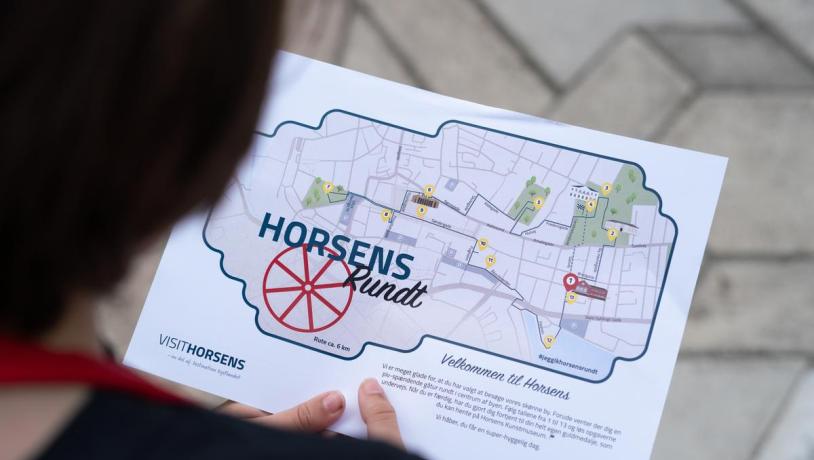 Child is holding a treasure map for the family activity "The Horsens Rundt Treasure Hunt"