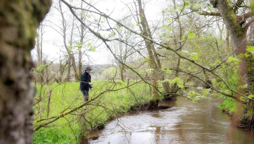 Man fishing from the banks of the river Gudenåen