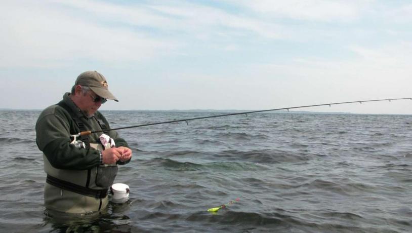 Man baiting a hook on a fishing trip