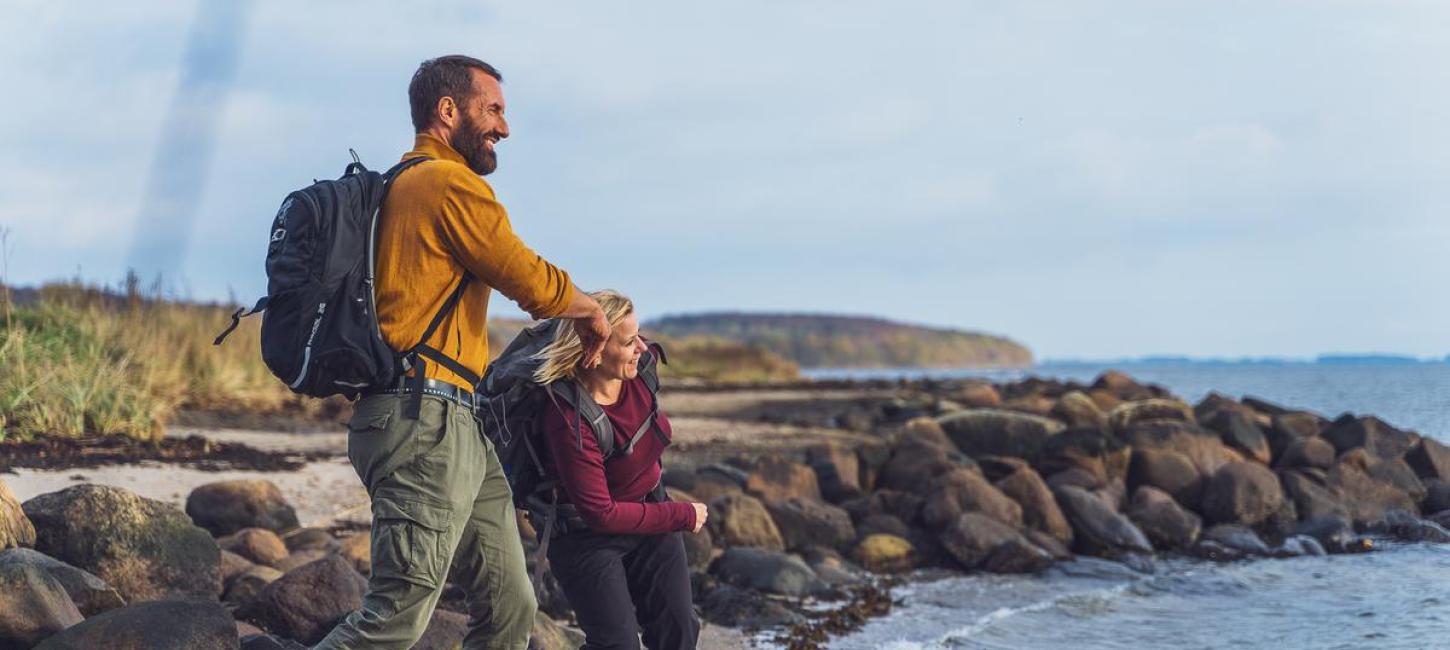 Two hikers skip stones at Horsens Fjord