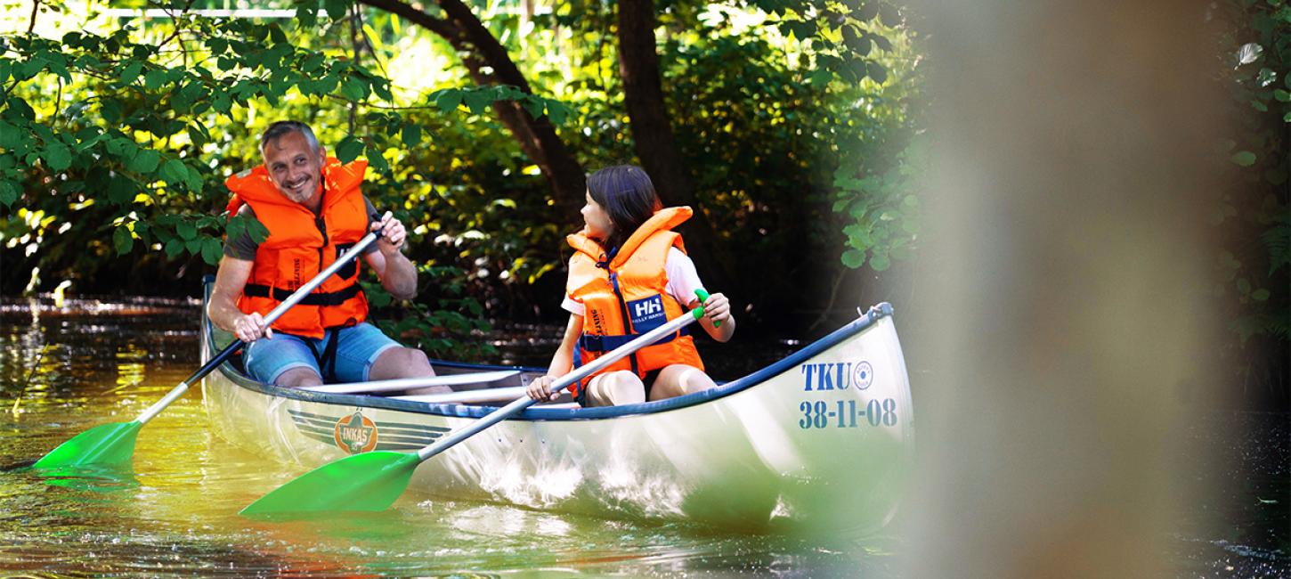 Father and daughter in a canoe on the Gudenå river in the Coastal Land