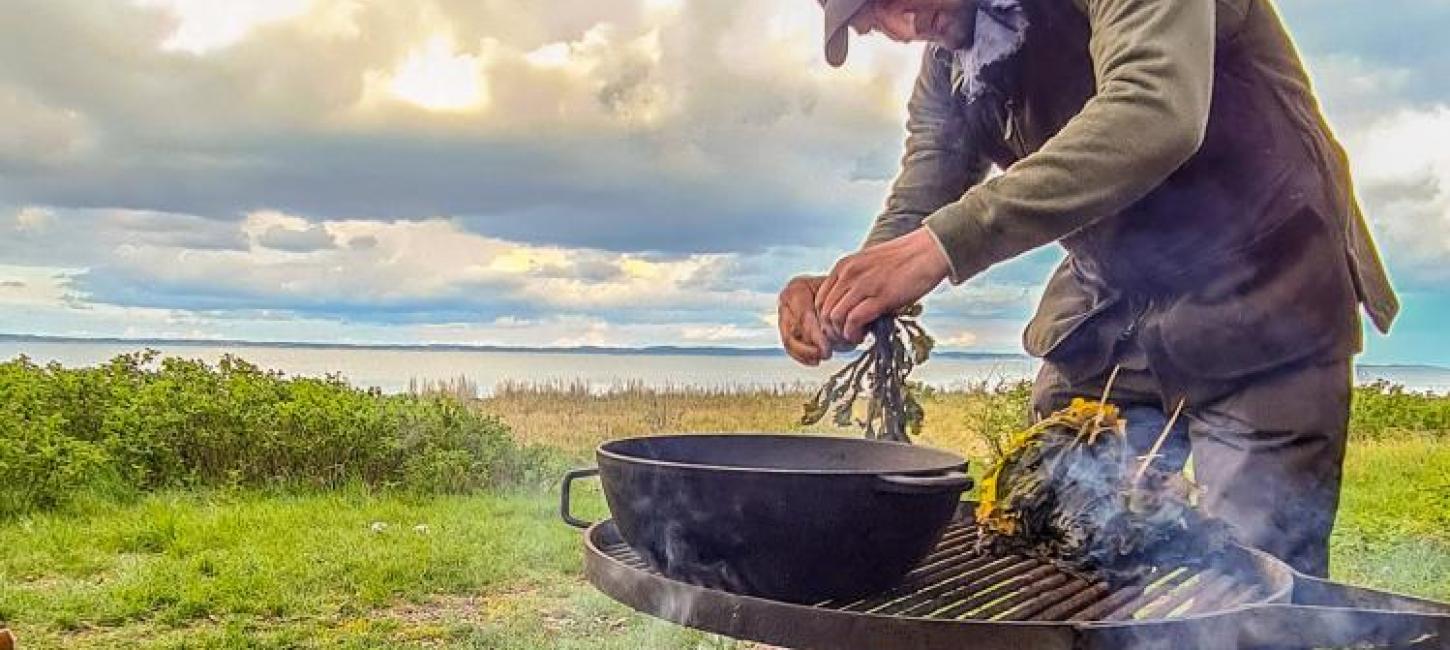 Man making food outdoor with fire