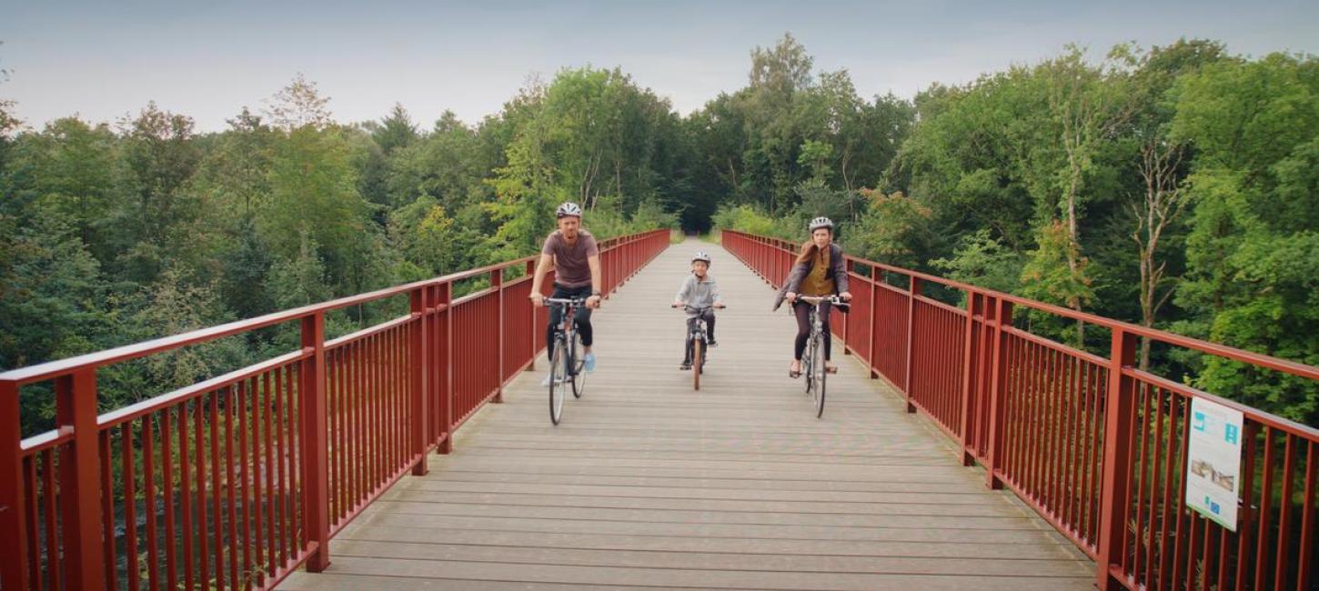 Family rides on their bikes on The Uncovered Bridge
