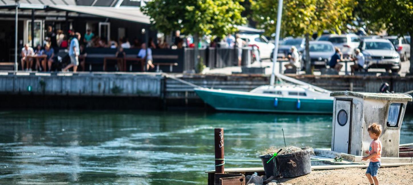 Boy standing by Norsminde harbour