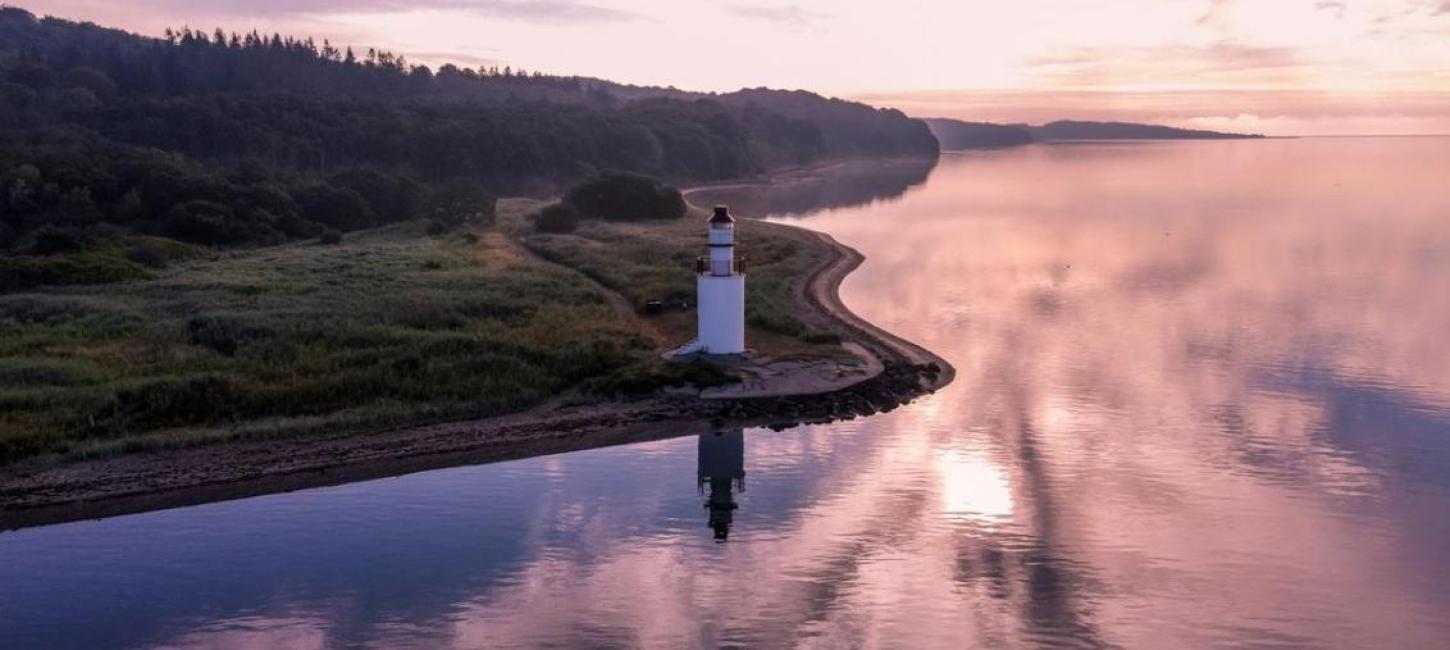 View of the coastal line and lighthouse in the area of Hotel Vejlefjord in the coastal land