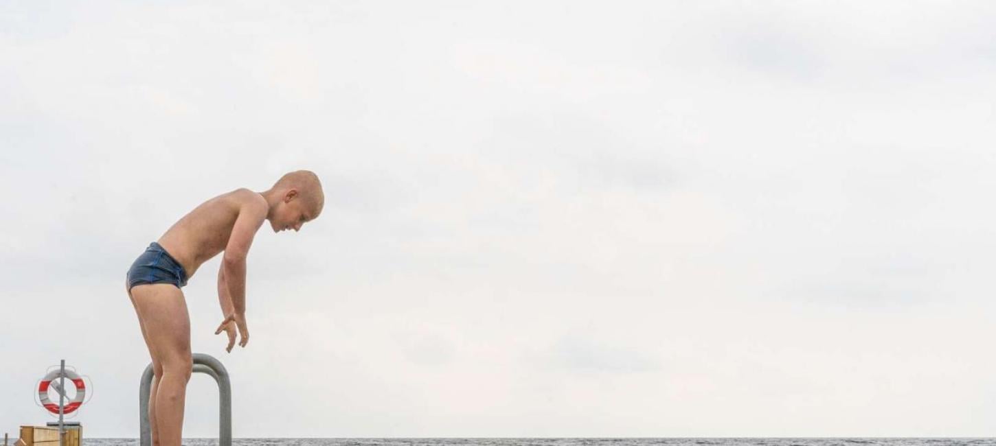 Boy standing on the jetty at Storstranden