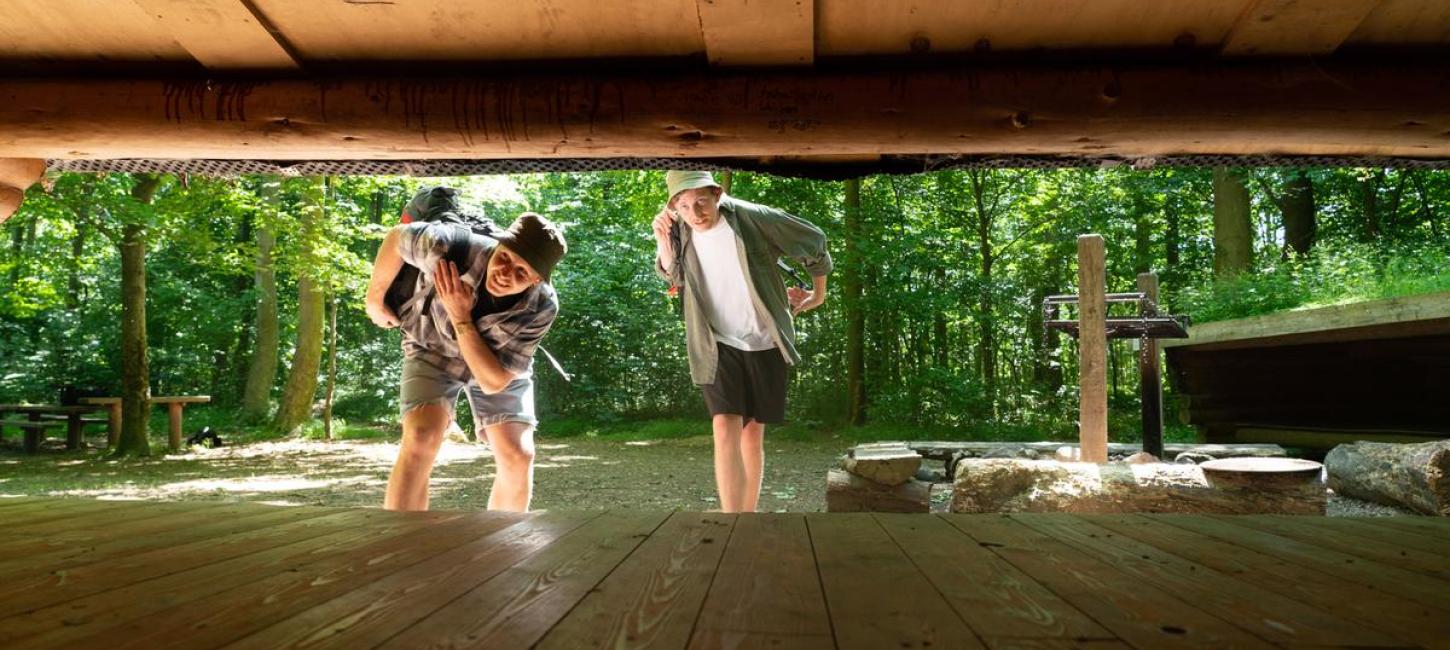 Two friends looking into a shelter in Destination Coastal Land