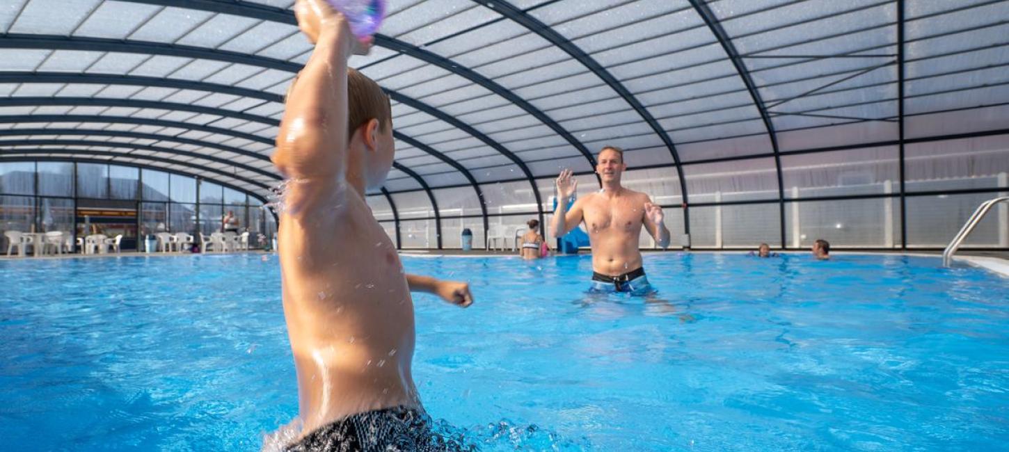 A boy and a father playing ball in a pool at Horsens City Camping near Husodde in Destination Coastal Land