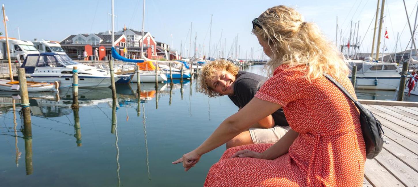 A couple enjoying themselves at the harbour in Denmark's cosiest harbour town, Juelsminde - part of Destination Coastal Land