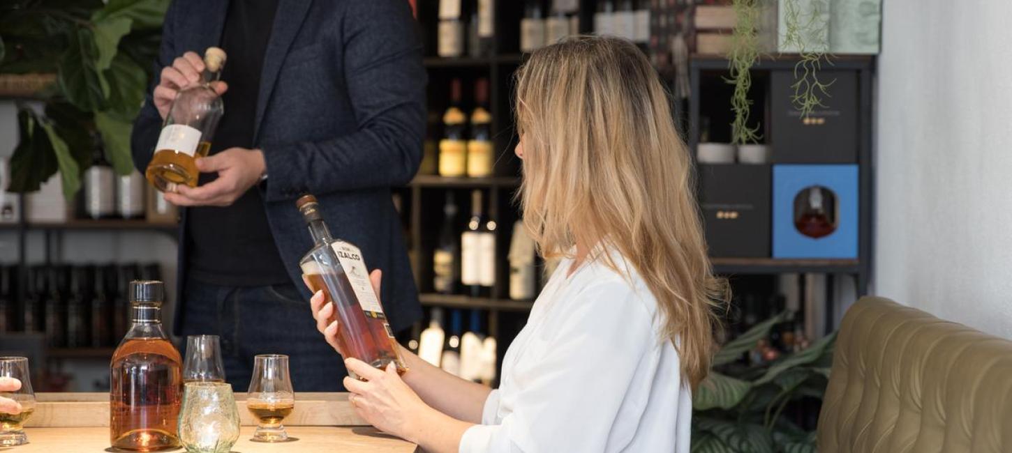 Lady holding a bottle of whisky in the specialty shop Water of Life at Mejeritorvet in Brædstrup
