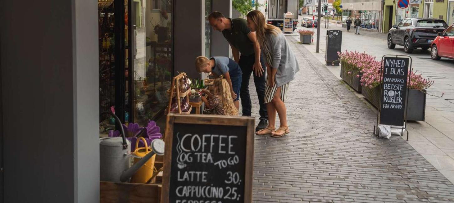 Family shopping looking at items outside a shop in Odder - part of Destination Coastal Land