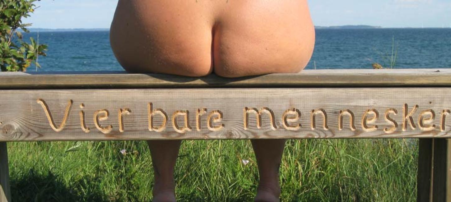 Bare buttocks on a bench at Kysting Beach, where the view is enjoyed from N.F.J. Naturist Camping