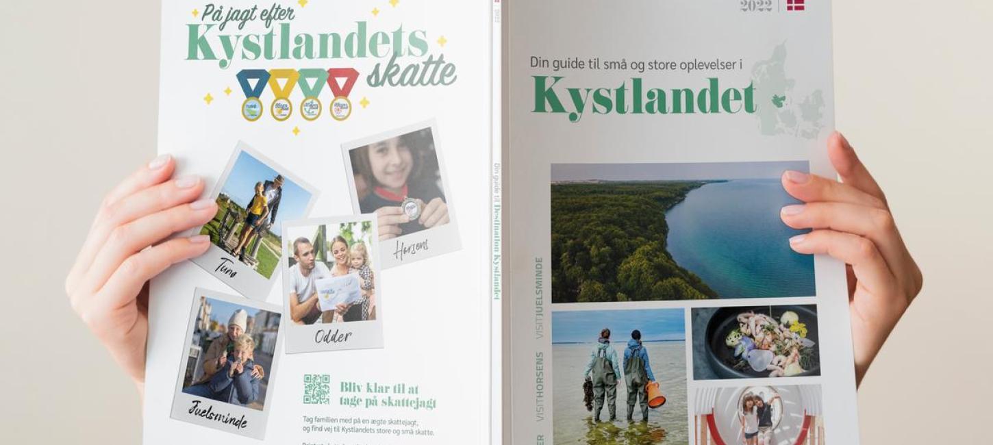 Woman is reading a brochure about the holiday destination Kystlandet