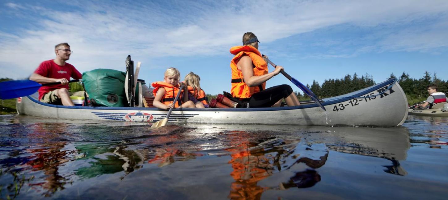 Familie sejler i kano på Gudenåen