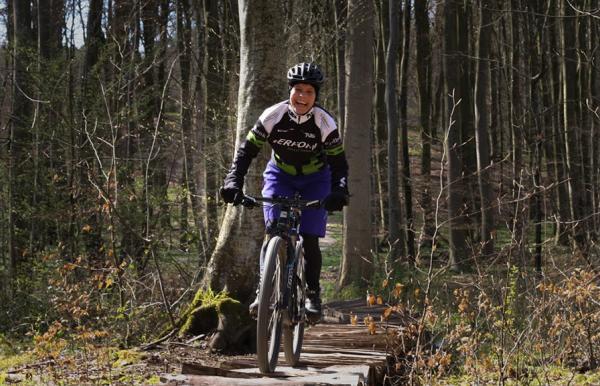 A woman riding a mountain bike on the trail in Tofte Forest in Juelsminde